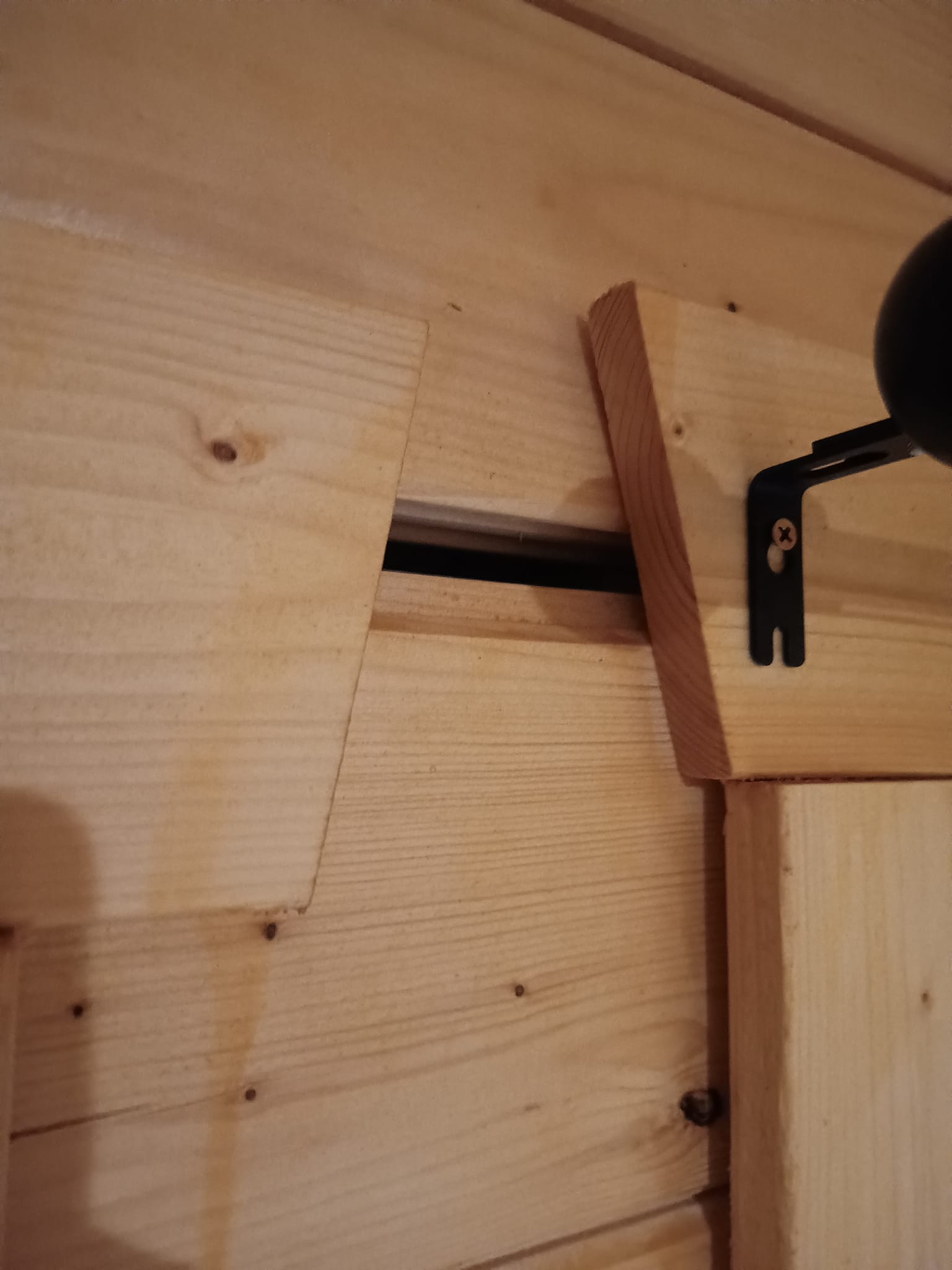 Fitting curtain poles to a log cabin wall